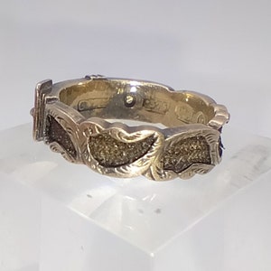 Puede incluir: Un anillo de oro con un diseño detallado de hojas. El anillo está engastado con una pequeña piedra y tiene un sello en el interior.