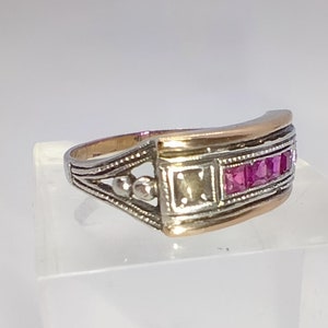 Peut inclure: Une bague en argent et or avec une rangée de pierres précieuses roses serties dans une bande décorative.