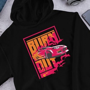 May include: Black hoodie with a red car graphic and the text "BURN OUT" in pink and orange. The car is surrounded by orange flames.