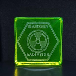 Op de afbeelding: Een set van drie keramische mokken met een gespikkelde, crèmekleurige glazuur. Elke mok heeft een ander handgeschilderd ontwerp: een blauw en groen blad, een gele bloem en een rode bes. De mokken hebben een eenvoudig, modern ontwerp.