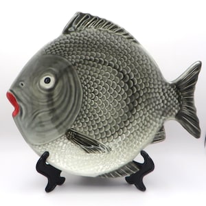 May include: A set of three ceramic mugs with a speckled, matte finish in cream, light grey, and dark grey. Each mug has a simple, minimalist design, suitable for coffee or tea.