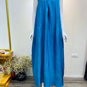 May include: A sleeveless maxi dress in a vibrant blue color. The dress has a loose, flowing fit and a simple, elegant design.