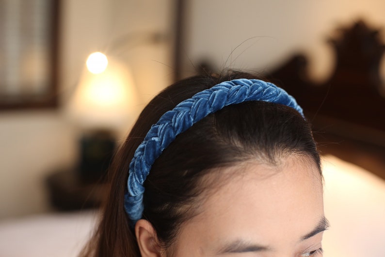 May include: A blue velvet braided headband for women. The headband is made of soft, comfortable material and is perfect for adding a touch of elegance to any outfit.