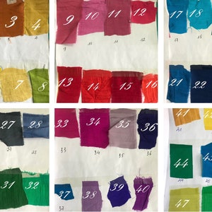 May include: A collection of 48 fabric swatches in various colors, numbered 1 through 48. The swatches are arranged in rows of four, with each row representing a different color family. The swatches are all approximately the same size and shape.