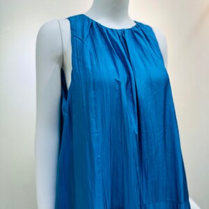May include: A sleeveless, blue, flowing dress with a gathered neckline.