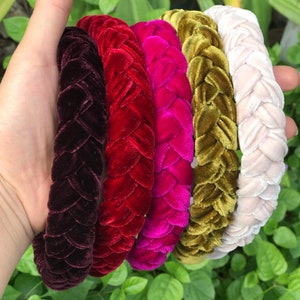 May include: Five braided velvet headbands in different colors: burgundy, red, fuchsia, olive green, and cream.