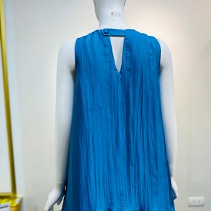 May include: A sleeveless maxi dress in a vibrant blue color. The dress has a V-neckline and a keyhole opening in the back. The fabric has a slightly textured, crinkled look.
