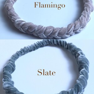 May include: Two braided velvet headbands, one in a light pink color labeled "Flamingo" and the other in a light blue color labeled "Slate".