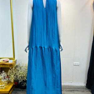 May include: A sleeveless maxi dress in a vibrant blue color. The dress has a V-neckline and a flowy, relaxed fit.