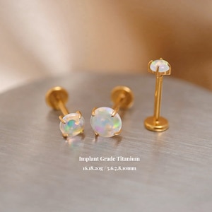 K&ouml;nnte beinhalten: Drei goldene Titan-Opal-K&ouml;rper-Schmuckst&uuml;cke. Zwei sind Ohrstecker mit 5,6, 7,8 und 8,1 mm Opal-Steinen. Der dritte ist eine Barbell mit einem 5,6 mm Opal-Stein. Implantat-Grade Titan 16.18.20g.