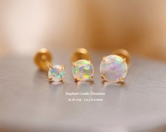 以下が含まれることがあります： 白いオパールストーンが付いたゴールドチタンオパールピアス3つ。ピアスの直径は5.6、7、8ミリメートルです。インプラントグレードチタン16.18.20g / 5.6、7、8.10mm