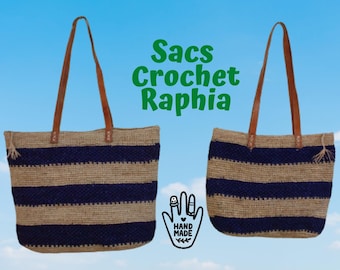 May include: Two striped tote bags made of natural raffia with blue stripes and brown leather handles. The text "Sacs Crochet Raphia" is displayed above the bags. The text "Hand Made" is displayed below the bags.