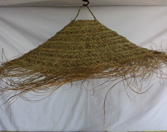 Peut inclure: Un grand abat-jour en fibres naturelles tissées avec une frange de longues mèches fines qui pendent. L'abat-jour est de couleur brun clair et a une forme conique.