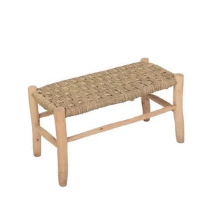 May include: A natural woven bench with a light brown wood frame. The bench has a rectangular seat and four legs.