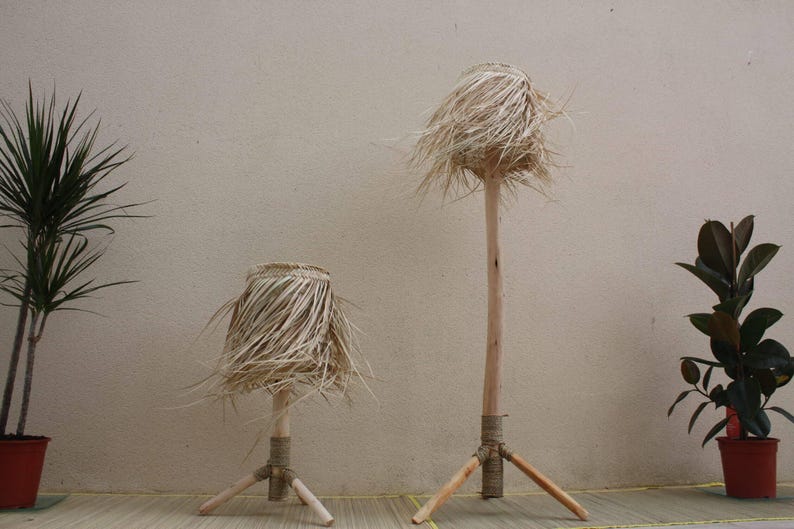 Puede incluir: Dos pantallas de l&aacute;mparas de tejido natural con bases de tr&iacute;pode de madera. La pantalla m&aacute;s grande est&aacute; a la derecha y la m&aacute;s peque&ntilde;a a la izquierda. Ambas l&aacute;mparas est&aacute;n sobre una superficie marr&oacute;n claro.