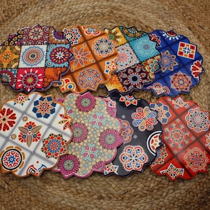 Può includere: Set di otto sottobicchieri in ceramica colorati con intricati motivi geometrici. Ogni sottobicchiere presenta un design diverso con un mix di colori rosso, blu, giallo, verde e bianco.