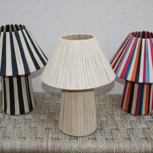 May include: Three table lamps with different striped shades. The shades are made of woven material and are in black and white, natural, and multi-coloured stripes.