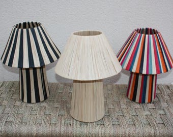 May include: Three table lamps with different striped shades. The shades are made of woven material and are in black and white, natural, and multi-colored stripes.