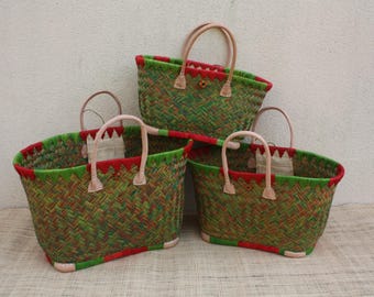 May include: Three woven baskets of varying sizes featuring a herringbone pattern in shades of green and red. Each basket has a bright green rim, a red accent band, and two light-colored leather handles attached with reinforced stitching.