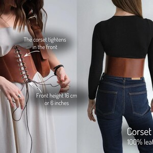 two different views of a corset belt. On the left, a woman is wearing a white dress and adjusting the corset belt, which is described as "The corset tightens in the front" and "Front height 16 cm or 6 inches". On the right, the same woman is wearing a black top and jeans, with the corset belt described as "Corset belt 100% leather".