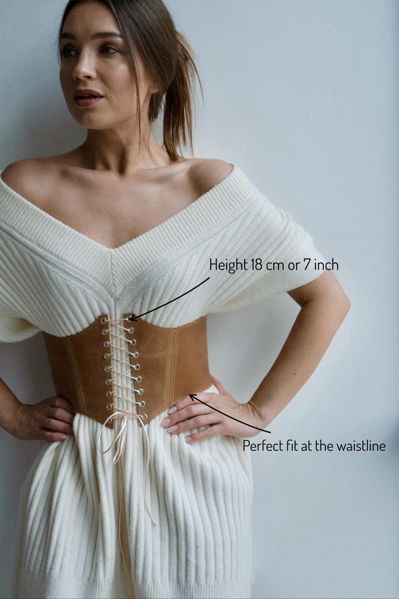 a woman wearing a white dress with a brown belt