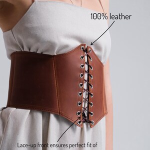 a woman wearing a brown leather corset