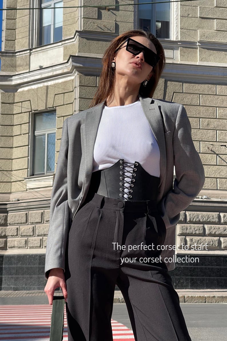 a woman in a business suit and sunglasses
