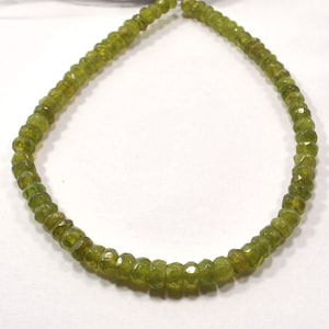 以下が含まれることがあります： 緑色の宝石ビーズのストランド。ビーズはファセットカットされており、わずかに不規則な形をしています。