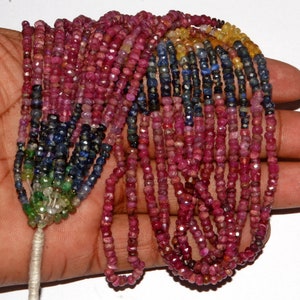 Puede incluir: Una hebra de cuentas de piedras preciosas en varios colores, incluyendo rojo, azul, verde y amarillo. Las cuentas son pequeñas y redondas, y están enhebradas en un hilo blanco.