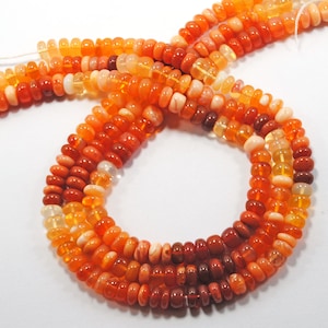 May include: A strand of orange, red, and yellow opal beads. The beads are round and have a smooth, polished finish.