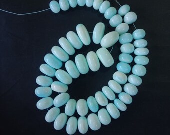May include: A strand of light blue oval-shaped beads. The beads are strung on a thin thread and are arranged in a spiral pattern.