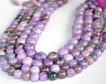 May include: A strand of purple and lavender gemstone beads. The beads are round and have a smooth, polished finish.