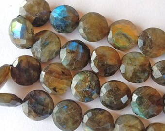 May include: A strand of faceted labradorite gemstone beads. The beads are a mix of brown, gray, and blue with iridescent flashes.