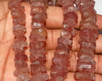 May include: A strand of pink and clear quartz beads, faceted and with a rough, natural texture. The beads are strung on a clear thread and are approximately 10mm in diameter.