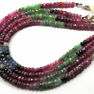 May include: A strand of gemstone beads in shades of pink, green, and blue. The beads are faceted and have a polished finish. The strand is approximately 18 inches long.