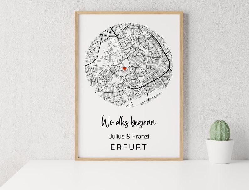 Pu&ograve; includere: Una mappa in bianco e nero di Erfurt, Germania, con un cuore rosso che segna una posizione. Il testo sotto la mappa recita "Wo alles begann" (Dove tutto &egrave; iniziato), "Julius & Franzi" e "ERFURT".