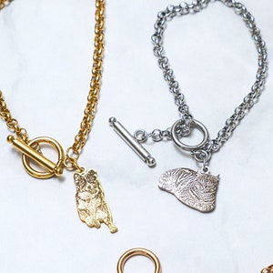 Puede incluir: Tres pulseras de encanto de perro en tono dorado con cierres de palanca. Los encantos son de diferentes razas de perros.