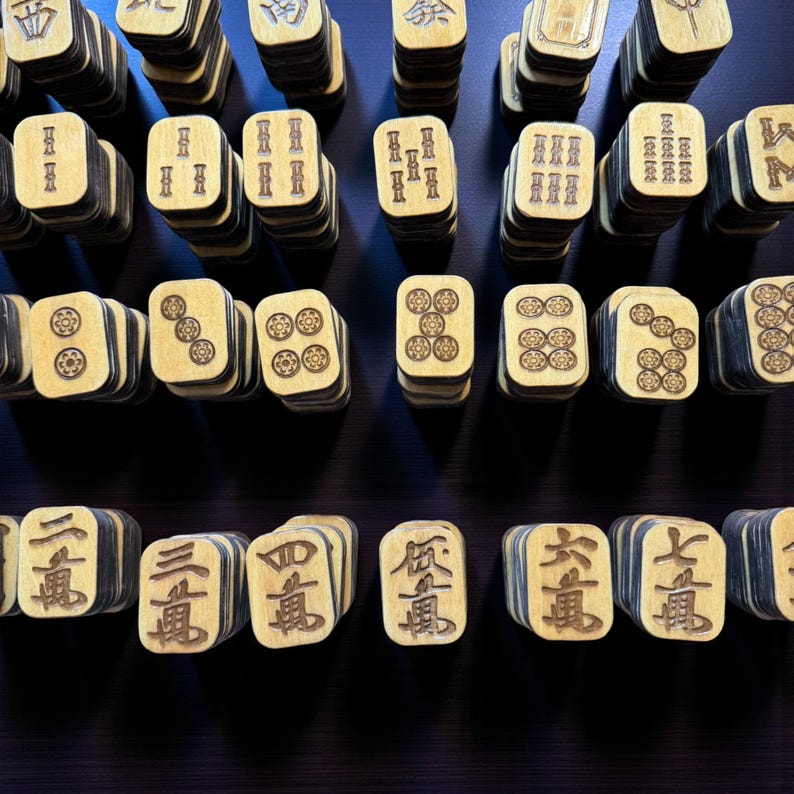 May include: A collection of wooden Mahjong tiles, each with unique symbols and characters. The tiles are stacked in rows, showcasing the variety of designs and the game's components. The wood has a light color with dark edges, creating a contrast.