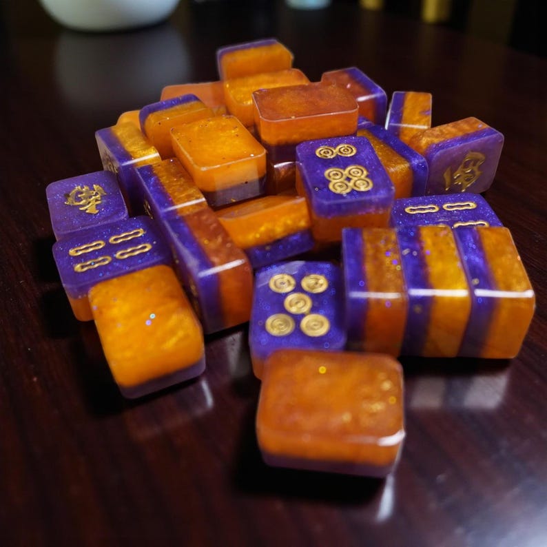 Mini Riichi Mahjong tile set with purple and orange resin design and gold inking.