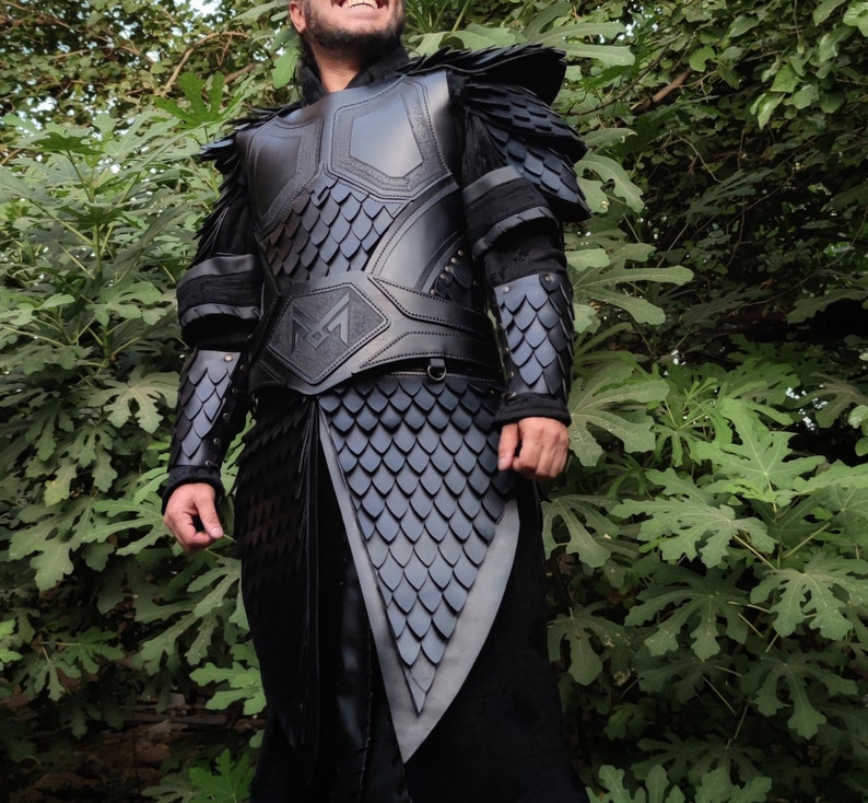 Puede incluir: Un traje de armadura de cuero negro con un patr&oacute;n de escamas y un cintur&oacute;n con hebilla. La armadura tiene un dise&ntilde;o decorativo en la pieza del pecho.