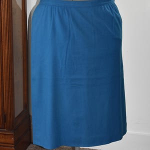 Op de afbeelding: Een turquoise rok gepresenteerd op een mannequin. De rok is effen van kleur, met een eenvoudige, rechte snit. De stof lijkt een materiaal van gemiddeld gewicht te zijn. De rok wordt gepresenteerd op een grijze mannequin.