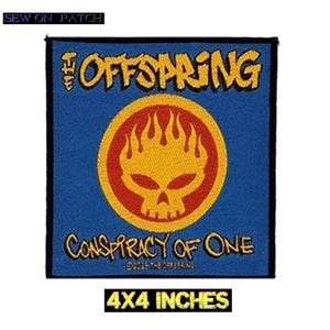 Peut inclure: Un écusson carré bleu avec le nom du groupe "The Offspring" en jaune au-dessus d'un crâne jaune et d'un motif de flammes dans un cercle rouge. Le texte "Conspiracy of One" est en dessous. L'écusson mesure environ 10 x 10 cm.