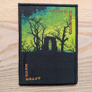 Può includere: Una toppa rettangolare nera con una grafica colorata. La metà superiore presenta un gradiente di verde e giallo con alberi e una struttura a silhouette. Il testo "TYPE O NEGATIVE" è in alto e "DARK AFTER" in basso.