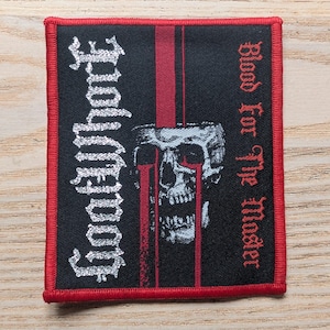 May include: Square black patch with a red border. The patch features the text "Godflesh" in white, vertically, and "Blood For The Master" in red. A detailed skull graphic is in the centre.
