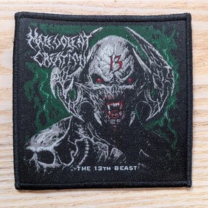 May include: Square black patch featuring a detailed illustration of a demonic creature with red eyes and sharp teeth. The creature has horns and the number "13" on its forehead. The text "HATE ETERNAL" is at the top, and "THE 13TH BEAST" is at the bottom.