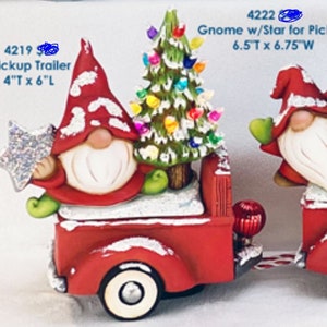 May include: A red pickup truck with a white gnome holding a silver star, a green Christmas tree with colorful lights, and a red ornament. The truck is 6.5 inches tall and 6.75 inches wide. The gnome is 4 inches tall and 6 inches long.