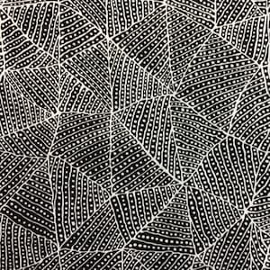 May include: Black and white fabric with a geometric pattern of triangles and dots. The pattern is reminiscent of Aboriginal art.