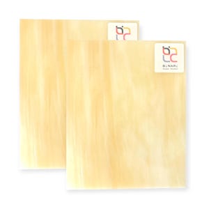 May include: Two rectangular sheets of pale yellow art glass with a streaked pattern. Each sheet has a small sticker in the upper right corner with a logo and the text "BINARI Glass Studio".