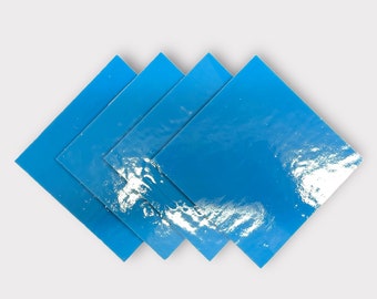 May include: Four blue square tiles with a white marbled pattern. The tiles are stacked on top of each other in a staggered pattern.