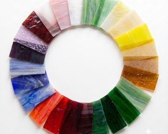 May include: A circular arrangement of rectangular stained glass samples in a spectrum of colors including white, pink, yellow, orange, red, purple, blue, and green. Each piece features unique textures and swirls. The text "비나리" is in the corner.